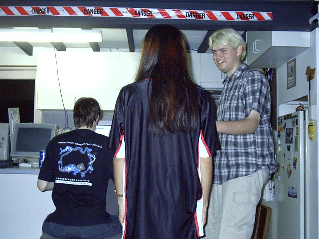The guys watch themselves on the web camera.